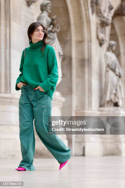 Cheyenne Ghanem wearing a green knitted turtleneck pullover by Bazilika, green wide leg cargo pants by Lioness, a blue bag by Chanel and hot pink...