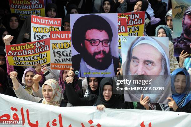 Turkish Muslim women hold portraits of former Hezbollah leader Abbas Musawi and Hamas spiritual leader Sheikh Ahmed Yassin and chant ant-Israeli...