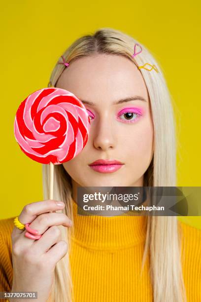 woman holding a large lollipop - pink eyeshadow stock-fotos und bilder