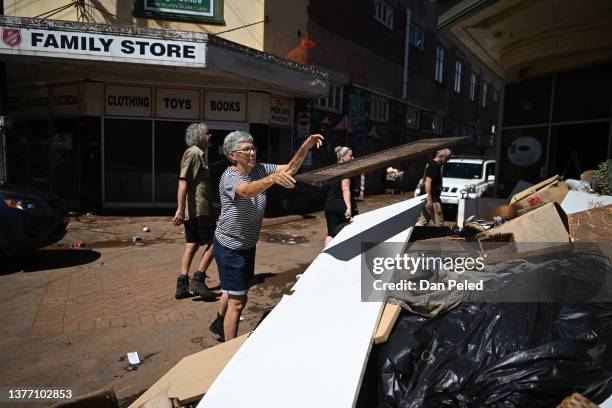 Woman throws away flood-damaged from a business on March 03, 2022 in Lismore, Australia. Several northern New South Wales towns have been forced to...