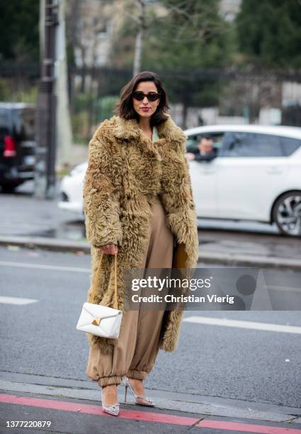 Bettina Looney seen wearing faux fur beige olive green coat, white bag, beige pants outside Cecilie Bahnsen during Paris Fashion Week - Womenswear...