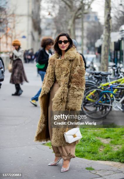 Bettina Looney seen wearing faux fur beige olive green coat, white bag, beige pants, heels outside Cecilie Bahnsen during Paris Fashion Week -...