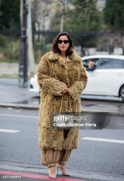 Bettina Looney seen wearing faux fur beige olive green coat, white bag, beige pants outside Cecilie Bahnsen during Paris Fashion Week - Womenswear...