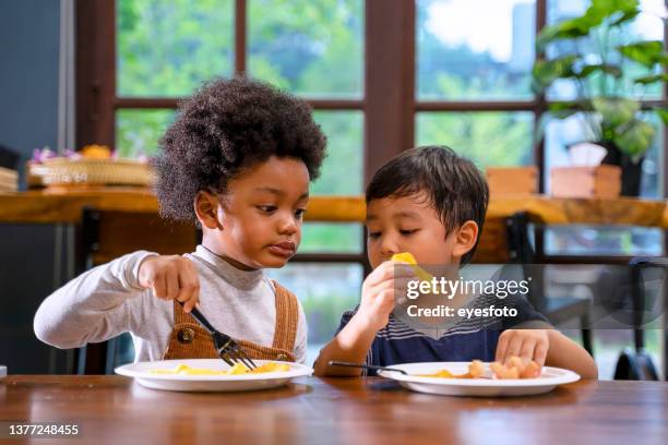 kids eat food with their friends. - kid eating restaurant stock pictures, royalty-free photos & images