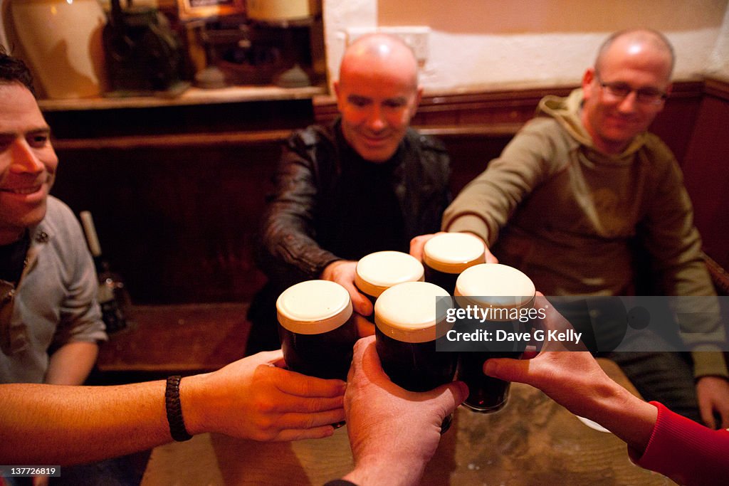 Men holding glasses of stout