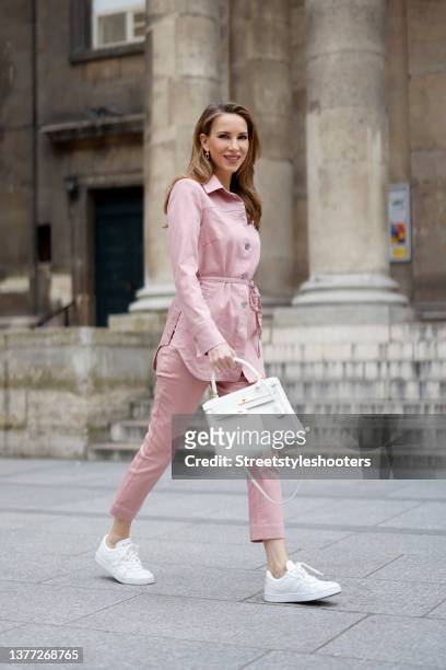 Influencer Alexandra Lapp wearing a pastel pink jacket and matching pants by Airfield, gold City HardWear earrings by Tiffany & Co. A white Kelly bag...