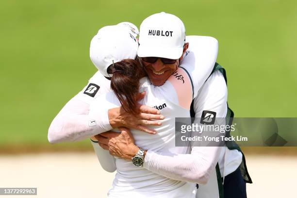 Jin Young Ko of South Korea celebrates with her caddie after putting for a birdie on the 18th green to finish the first round of the HSBC Women's...
