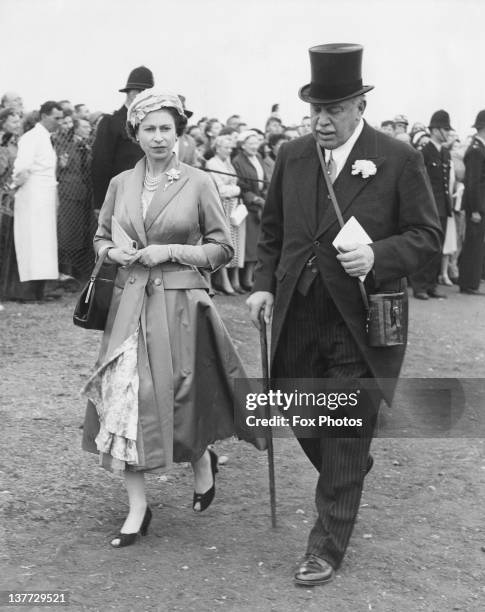 Queen Elizabeth II returning from the paddock with politician and racehorse owner Harry Primrose, 6th Earl of Rosebery at the Derby, Epsom Downs...