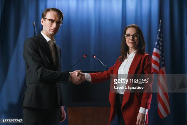 white american politicians shaking hands at the debates on a blue background with american flag - all the presidents men stock pictures, royalty-free photos & images