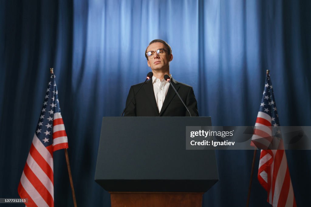 Low angle view at the serious young American politician looking away during his speech at the debates
