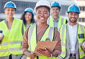 Cropped portrait of an attractive female construction worker standing on a building site with her colleagues in the background