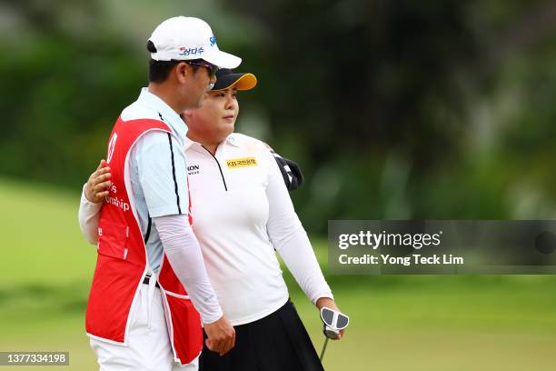 Inbee Park of South Korea and her caddie and husband Gi Hyeob Nam embrace on the 18th green after finishing the first round of the HSBC Women's World...