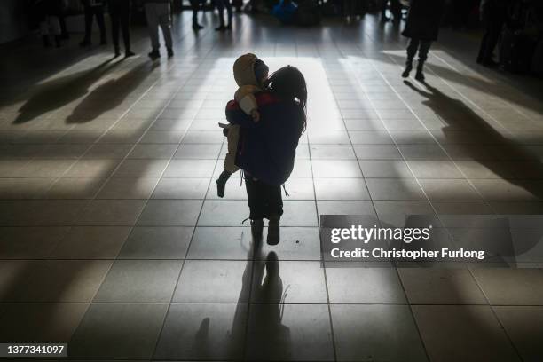 Refugee girl carries a sibling after arriving at the Hungarian border town of Zahony on a train that has come from Ukraine on March 03, 2022 in...