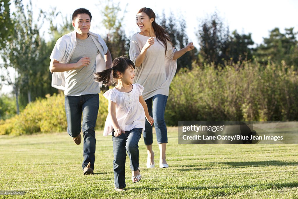 Young family running in a field