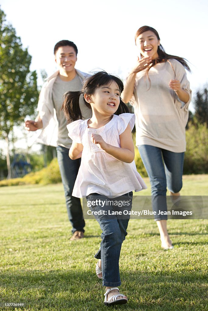 Young family running in a field