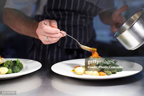 chef preparing dish in kitchen - fine dining restaurant stockfoto's en -beelden