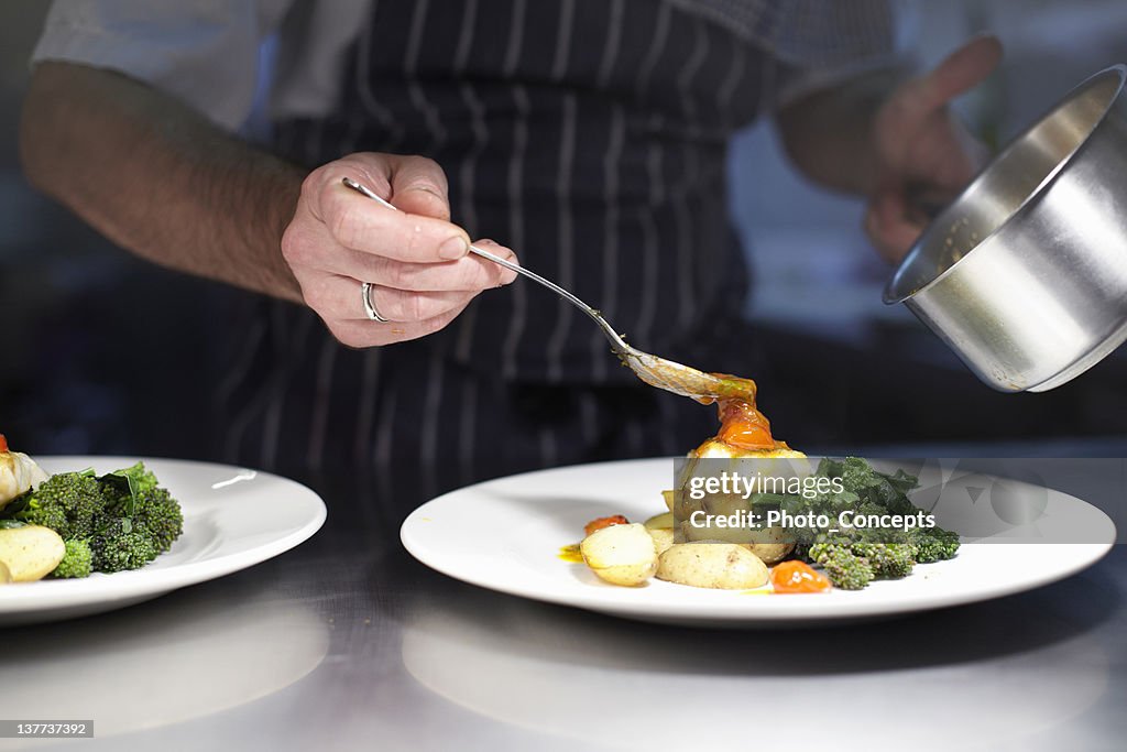 Chef preparing dish in kitchen