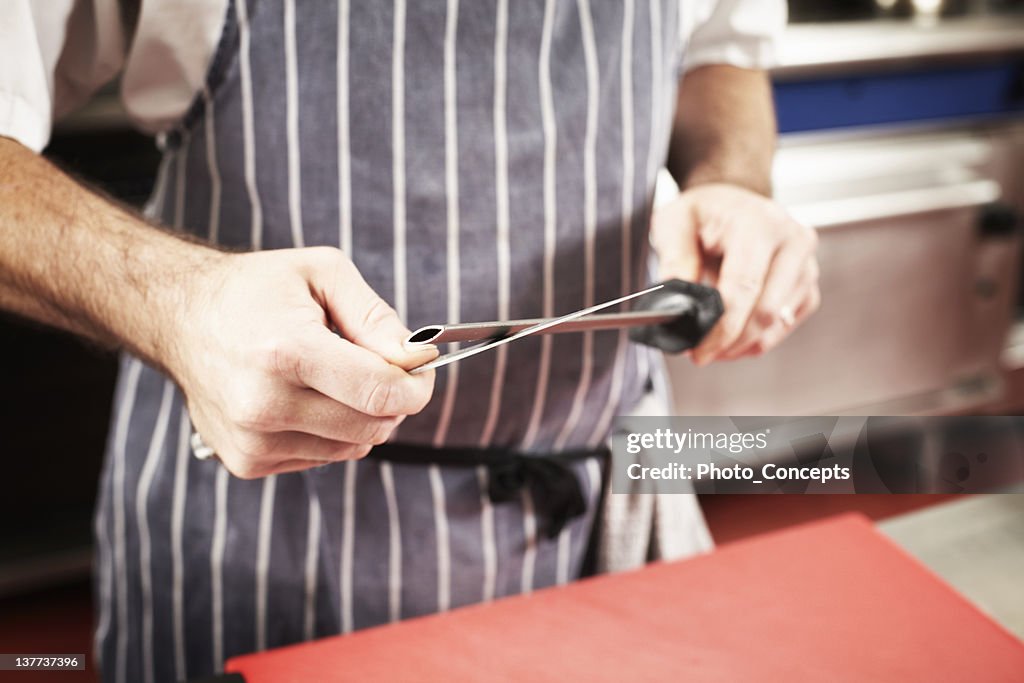 Close up of chef sharpening knife