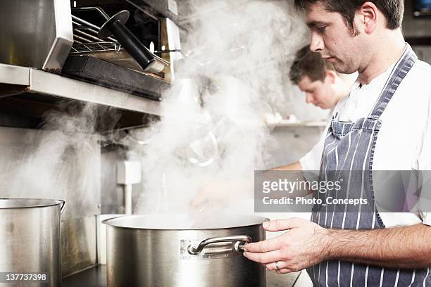 chef boiling water in kitchen - boiling water stock pictures, royalty-free photos & images