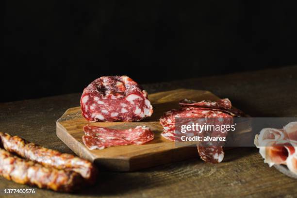 thinly sliced salami on a wooden cutting board - pork cuts stock pictures, royalty-free photos & images