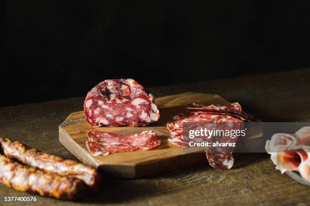 thinly sliced salami on a wooden cutting board - charcuterie board 個照片及圖片檔