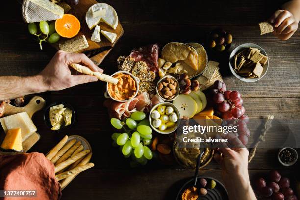 close-up of people eating cheese and meat platter - charcuterie board 個照片及圖片檔
