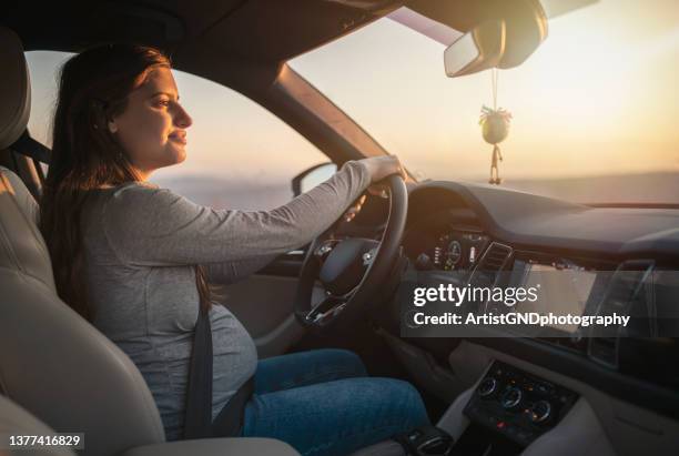 pregnant woman driving a car. - pregnant woman car stock pictures, royalty-free photos & images