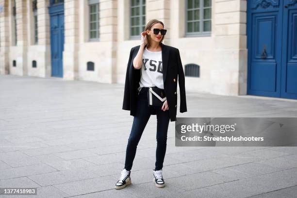Influencer Alexandra Lapp wearing a black blazer by Balmain, a white t-shirt by Saint Laurent, dark blue "u2018Maria"u2019 denim pants by Jbrand, a...