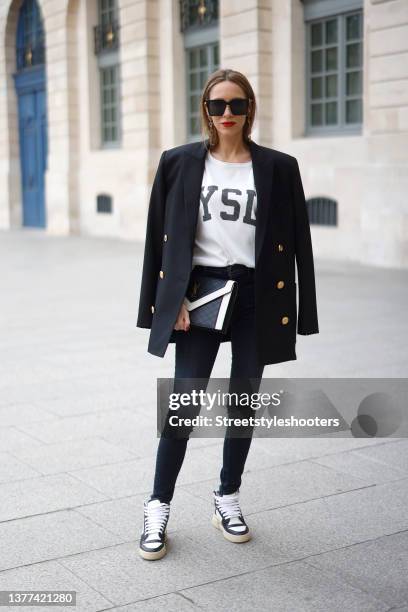 Influencer Alexandra Lapp wearing a black blazer by Balmain, a white t-shirt by Saint Laurent, dark blue "u2018Maria"u2019 denim pants by Jbrand, a...