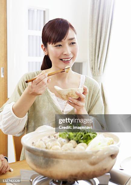 young woman eating japanese hot pot - mizutaki stock pictures, royalty-free photos & images