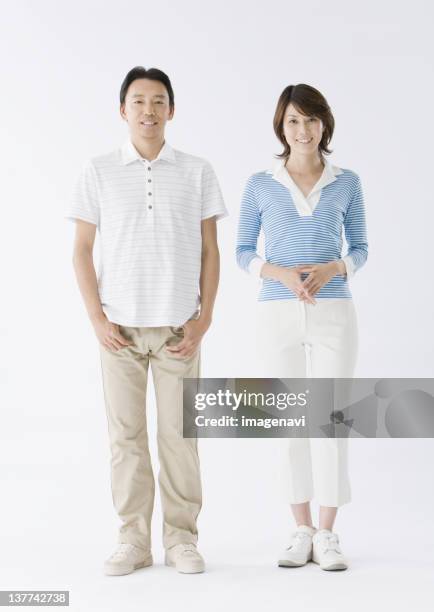 couple standing side by side - woman poloshirt stockfoto's en -beelden