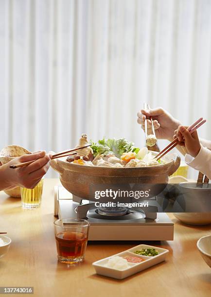 family's hands eating japanese hot pot - hot pots stockfoto's en -beelden