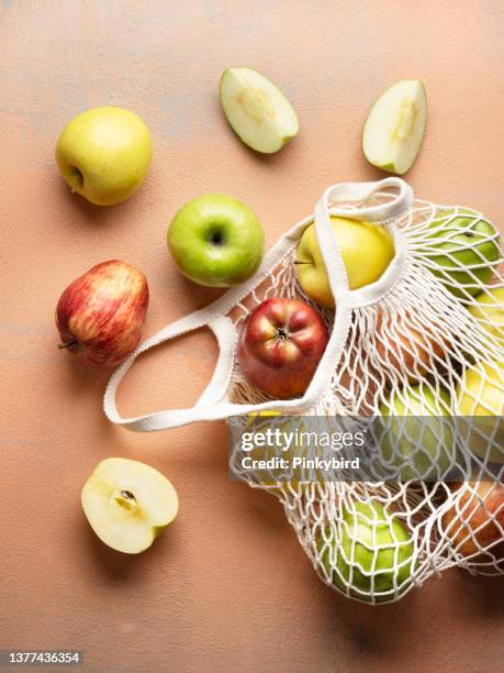apples, ripe apples in shopping bag on background, apples on the colored background. ripe different apples - drawstring bag stock pictures, royalty-free photos & images