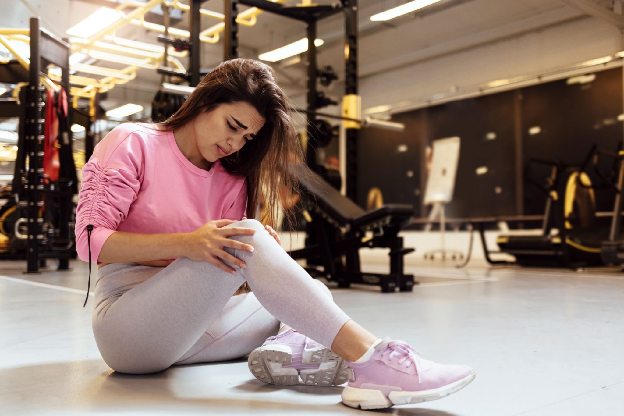 a woman holding her knee due to workout injury a woman holding her knee due to workout injury