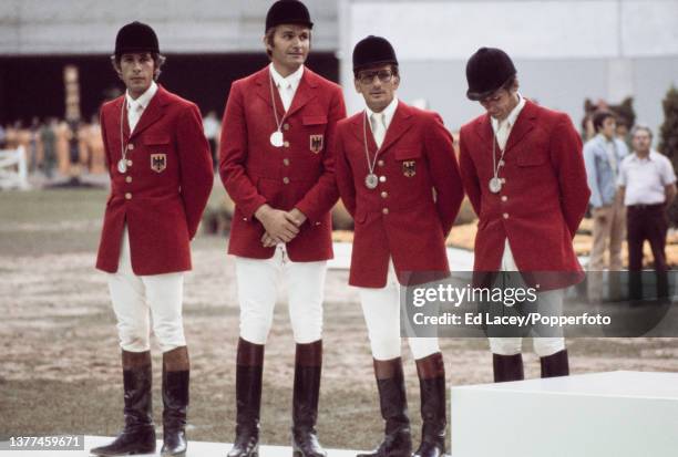 The West Germany team of Alwin Schockemohle, Paul Schockemohle, Hans Gunter Winkler and Sonke Sonksen stand on the medal podium after finishing in...