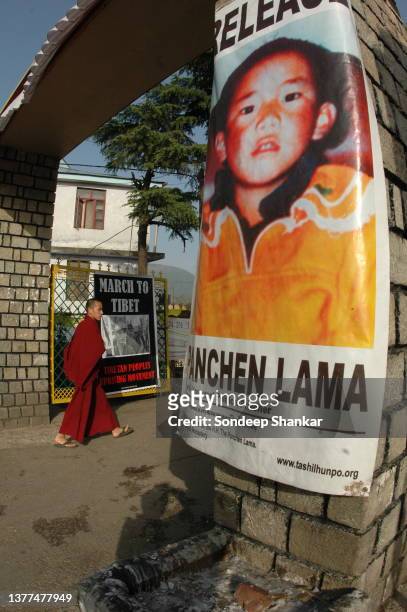 Tibetan refugees settled in Mc Leod Ganj, Dharamsala walks past a poster demanding release of Panchen Lama, a young religious head who is under...