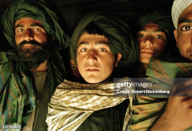 Young Taliban attending a madrassa March 1, 2000 in Sangesar, Afghanistan congregate near the adobe mud apartment where Mullah Omar, the leader of...