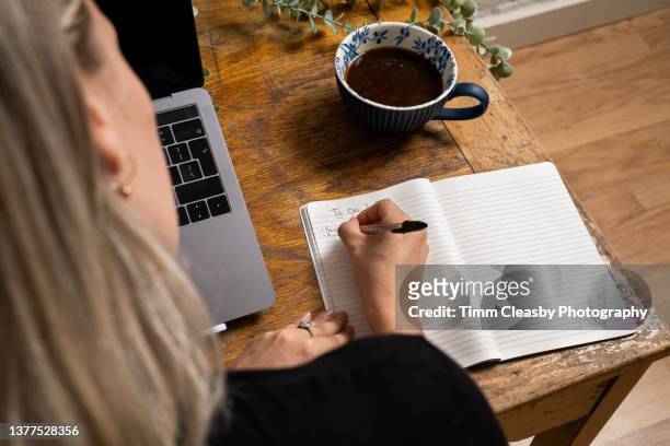 close-up of woman writing to do list in notepad - list stock pictures, royalty-free photos & images