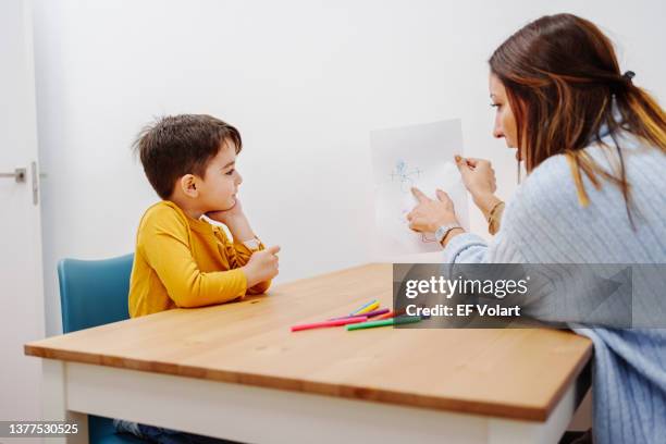 psychology exercise for children, kid drawing family together with young educational therapist - child psychologist stock pictures, royalty-free photos & images