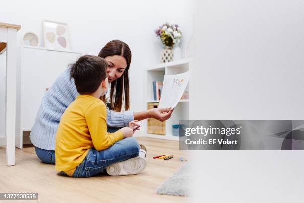 professional child education therapist talking about family with a kid in a family support center - neurodiversity stock pictures, royalty-free photos & images
