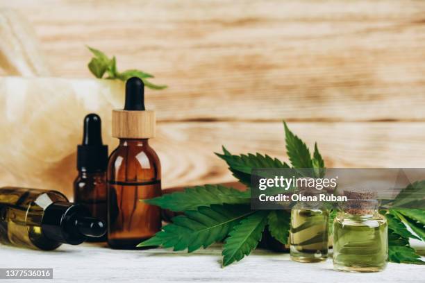 cbd oil in flacons, green cannabis, jade mortar and pestle - cannabis oil - fotografias e filmes do acervo