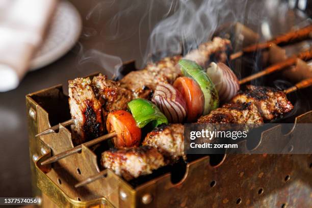 shashlik and vegetables on skewer grilled on mini barbecue - kalfsvlees stockfoto's en -beelden