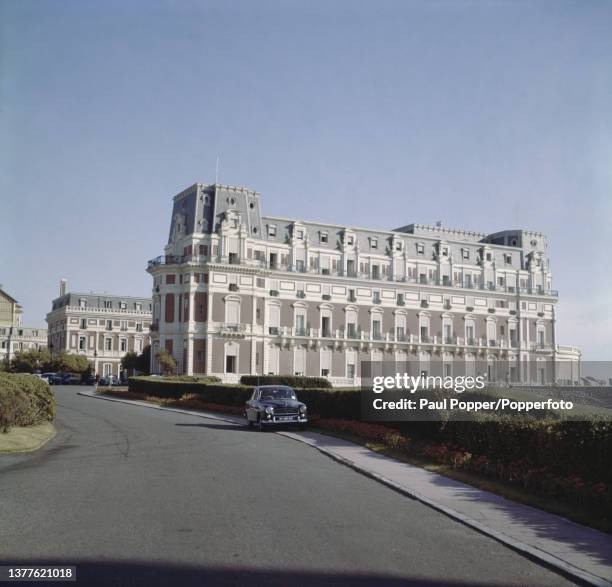 Cars parked beside the Hotel du Palais on the Atlantic coast beach in the city of Biarritz in the Pyrenees-Atlantiques departement of southwestern...