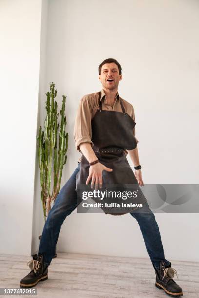 expressive craftsman dancing in craft studio - cool man leather stock pictures, royalty-free photos & images