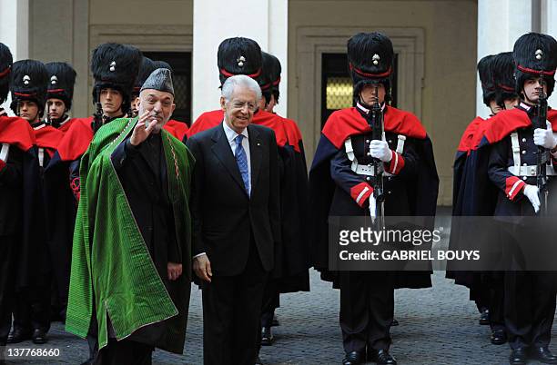 Italian Prime Minister Mario Monti greets Afghanistan's President Hamid Karzai prior their meeting on January 26, 2012 at Plazzo Chigi, Italy's Prime...