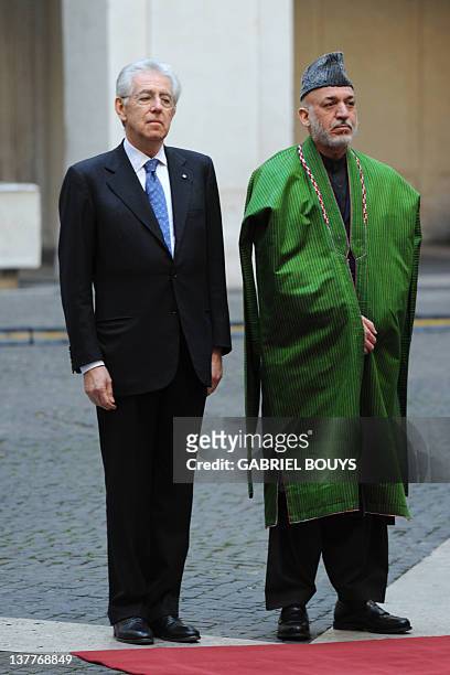 Italian Prime Minister Mario Monti and Afghanistan's President Hamid Karzai review an honour guard prior their meeting on January 26, 2012 at Palazzo...