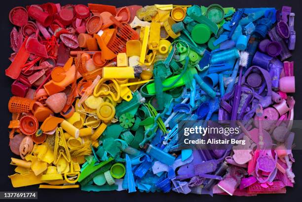 rainbow of coloured plastic pollution from the sea - green lighter stock pictures, royalty-free photos & images