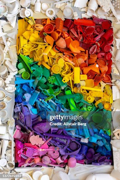 rainbow of coloured plastic pollution from the sea - bottle cap stock pictures, royalty-free photos & images