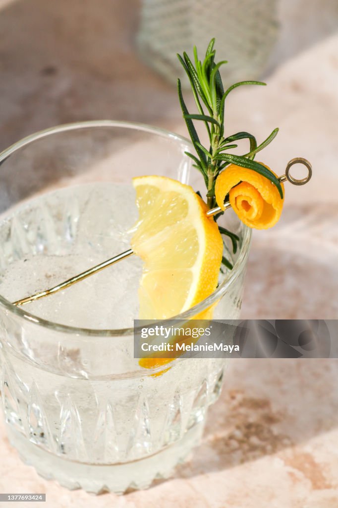 Cóctel de bebida alcohólica Gin Tonic con ralladura de limón y romero