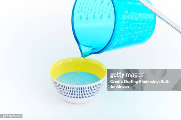 pouring liquid into a bowl - measuring cup imagens e fotografias de stock